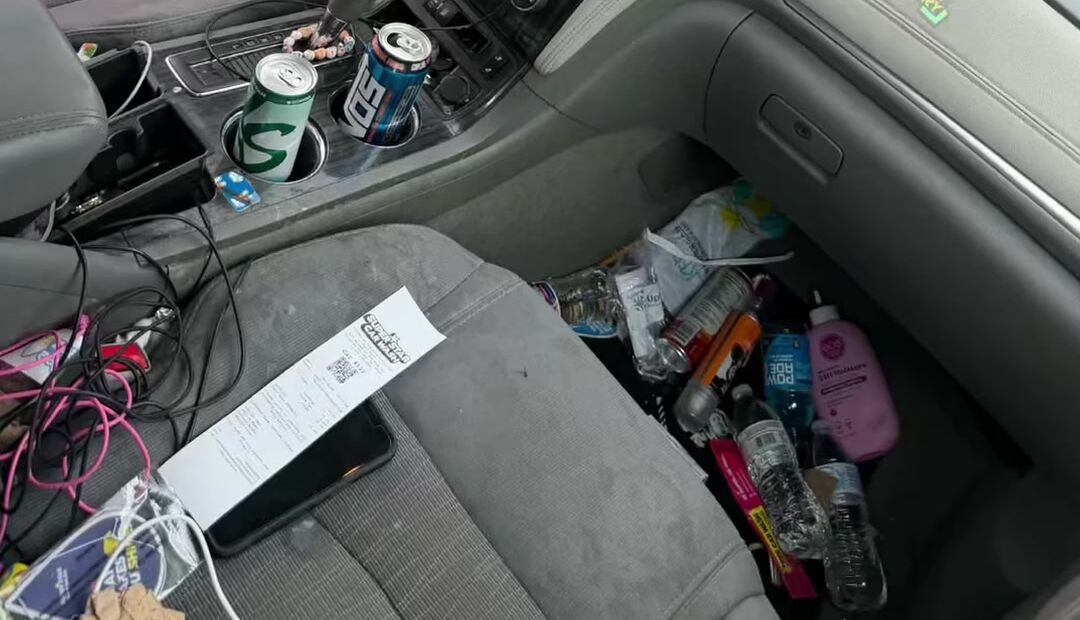 Chevy Traverse front seat covered in bottles, wrappers and trash before the detail