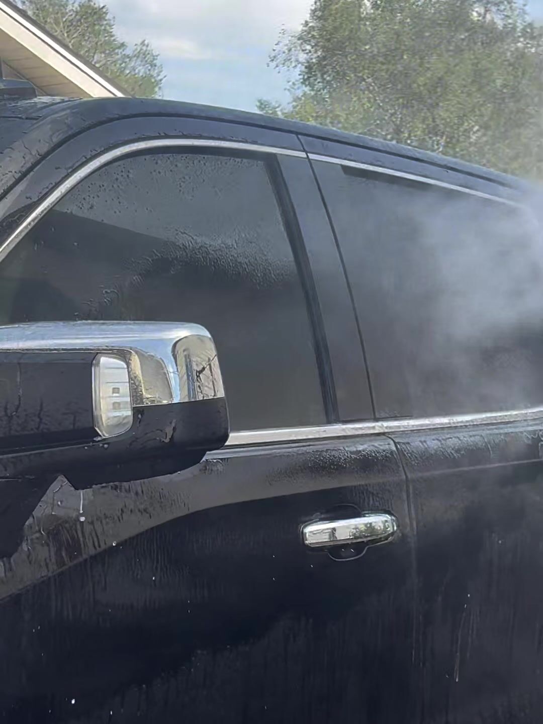 Water sheeting off the black door of a GMC Sierra