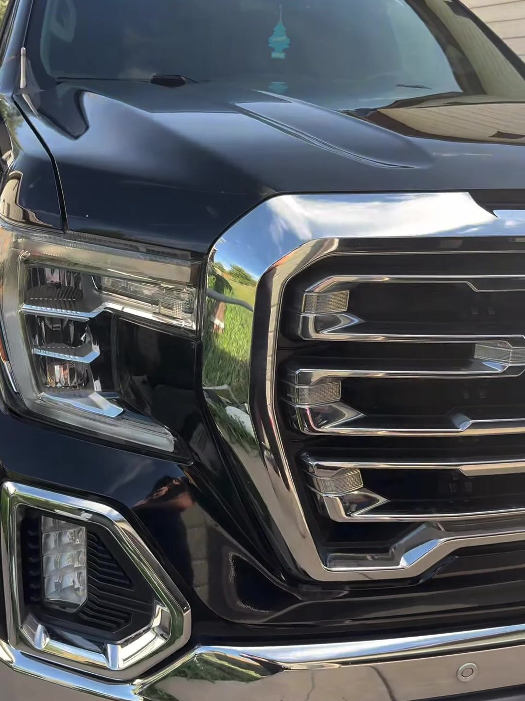 GMC Sierra chrome grille and black paint after a wash